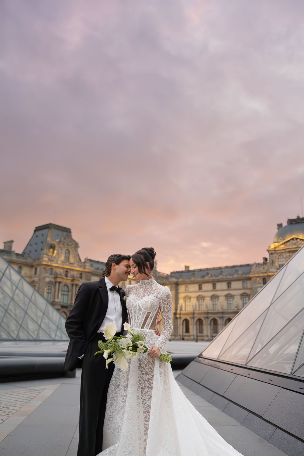 Sunset wedding photoshoot at the Louvre with glass pyramid in background.