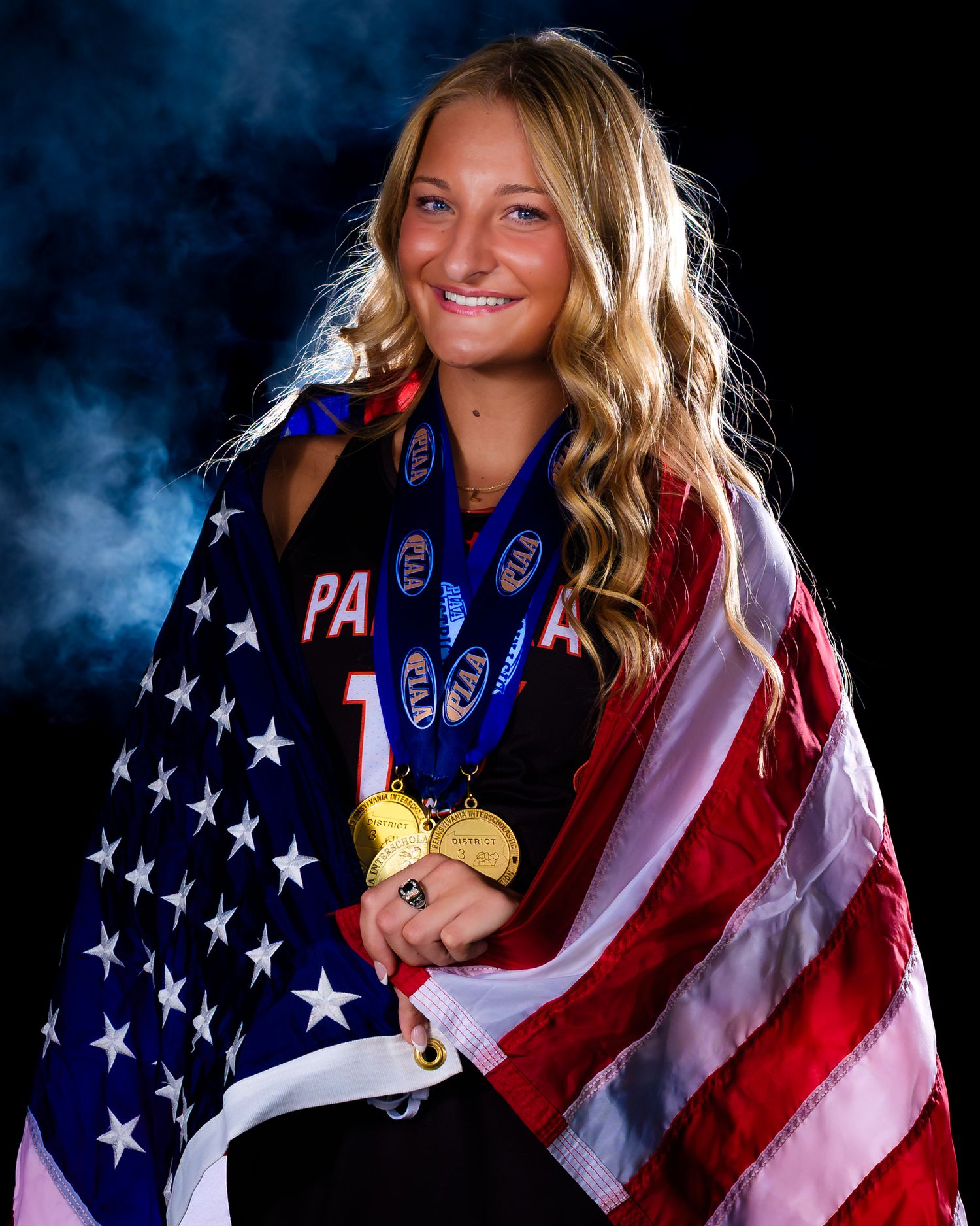 Leigha Kane senior field hockey portrait draped in the American flag with medals, by Deanna Fox, SportsFox Photography based in Hershey PA