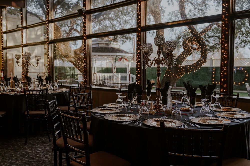 Elegant reception venue with round tables set for dinner near large windows.