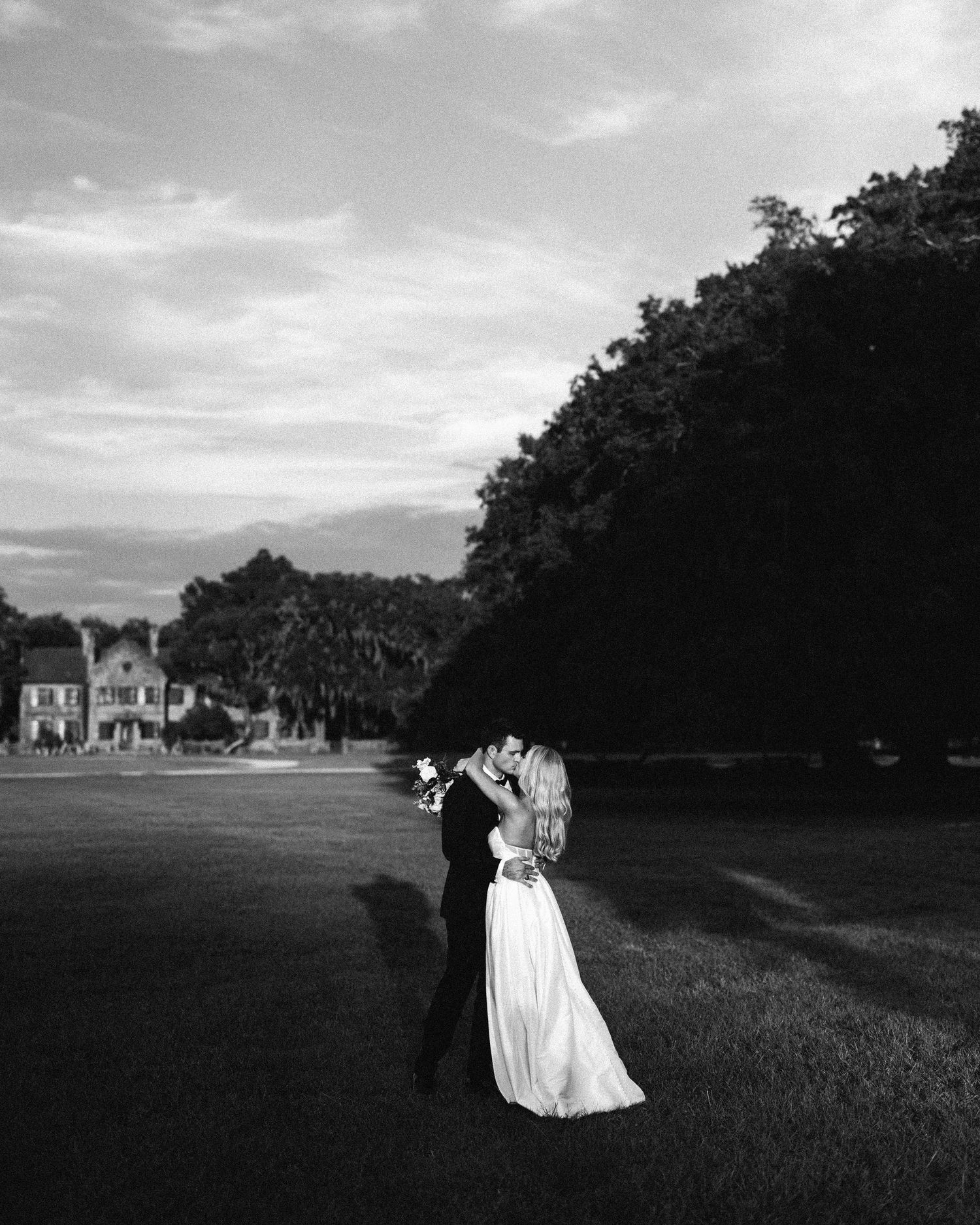 Happy newlyweds, celebrating their marriage, laughing in front of an old historic building at the Middleton Place Gardens in Charleston, SC