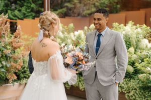 A wedding couple shares intimate moments in a lush garden setting with soft natural lighting and elegant attire.