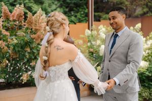 A couple shares a joyful moment together in a garden setting during their wedding celebration.