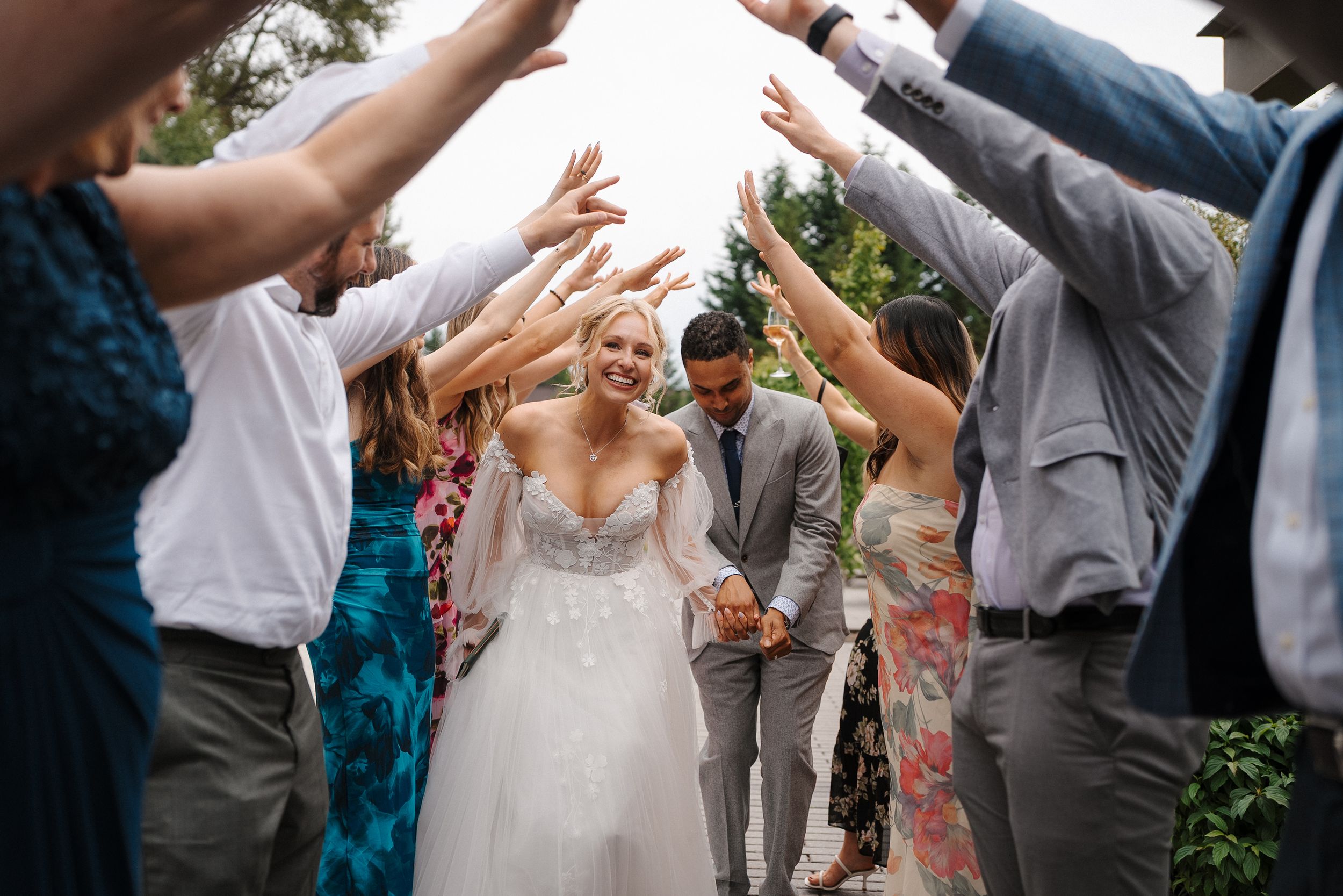 Wedding guests form a circle on a patio for a traditional celebration dance.