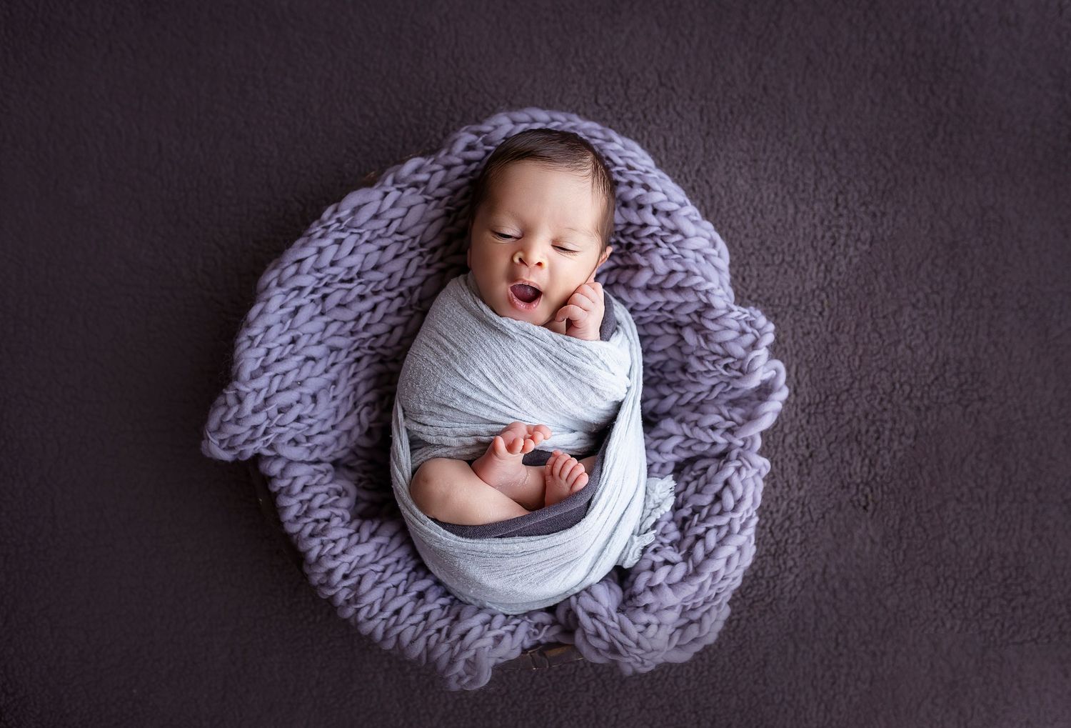 Fotografa de Ponce Puerto Rico fotografia a bebes recien nacidos en su estudio bebe posando dentro de una canasta bostezando