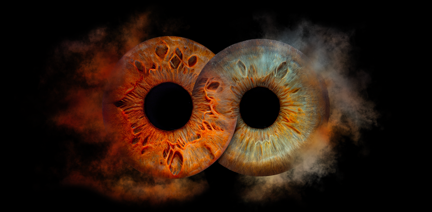 Two glowing eyes with zodiac symbols in their irises surrounded by orange and blue cosmic smoke effects.