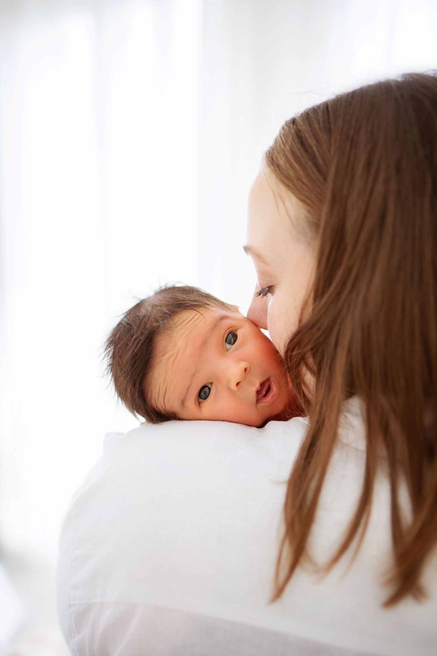 Ett ömt ögonblick mellan förälder och baby på mammas axel