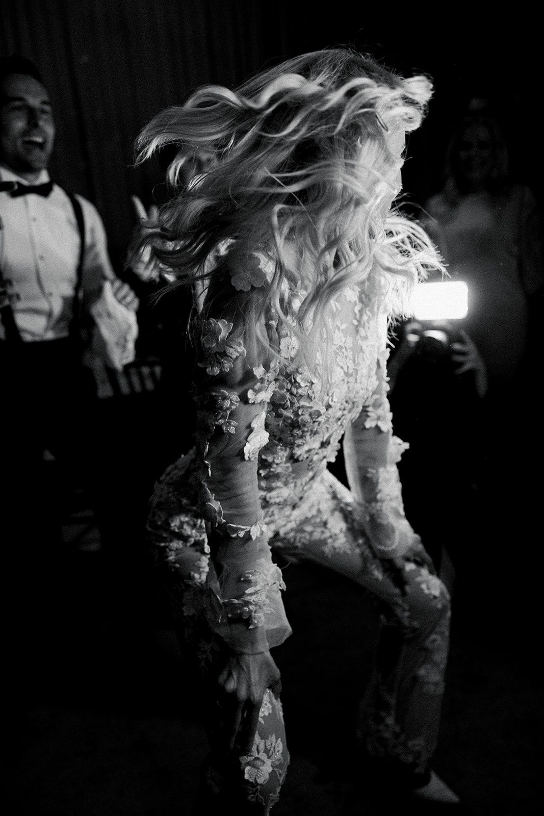 A black and white photo series shows a person with flowing hair dancing in dramatic motion against a dark background.