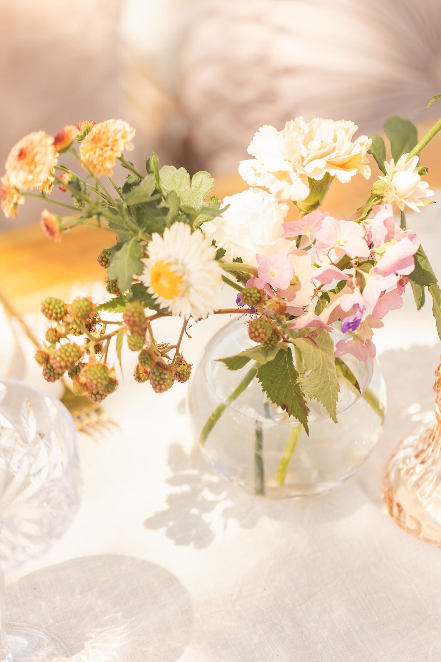 Soft pastel flowers and greenery arranged in an elegant display against a light background.
