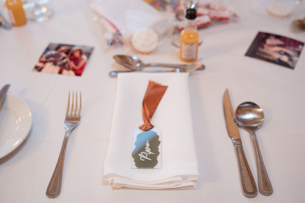 Place settings at a formal dining table show elegant silverware and white napkins arranged in a row.