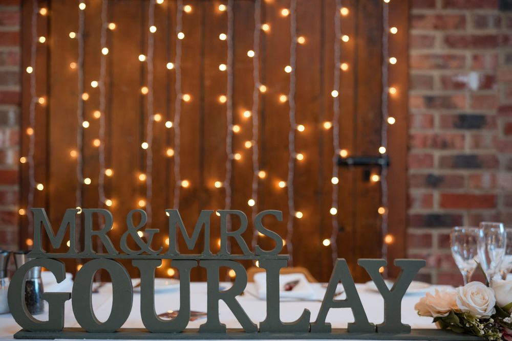 A rustic wedding reception venue with exposed brick walls and warm string lights creating an intimate atmosphere.