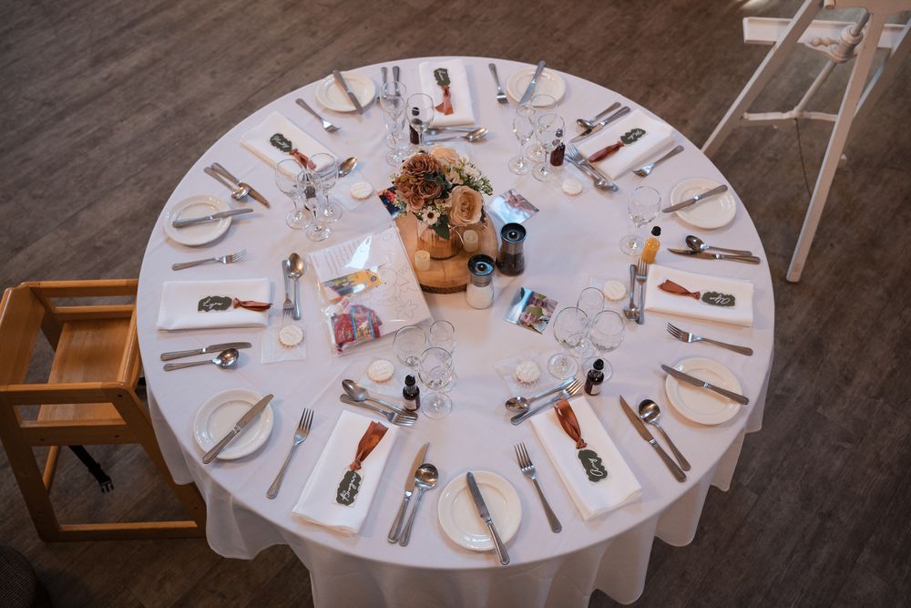 Round banquet tables with white tablecloths and formal place settings arranged for an elegant dining event.