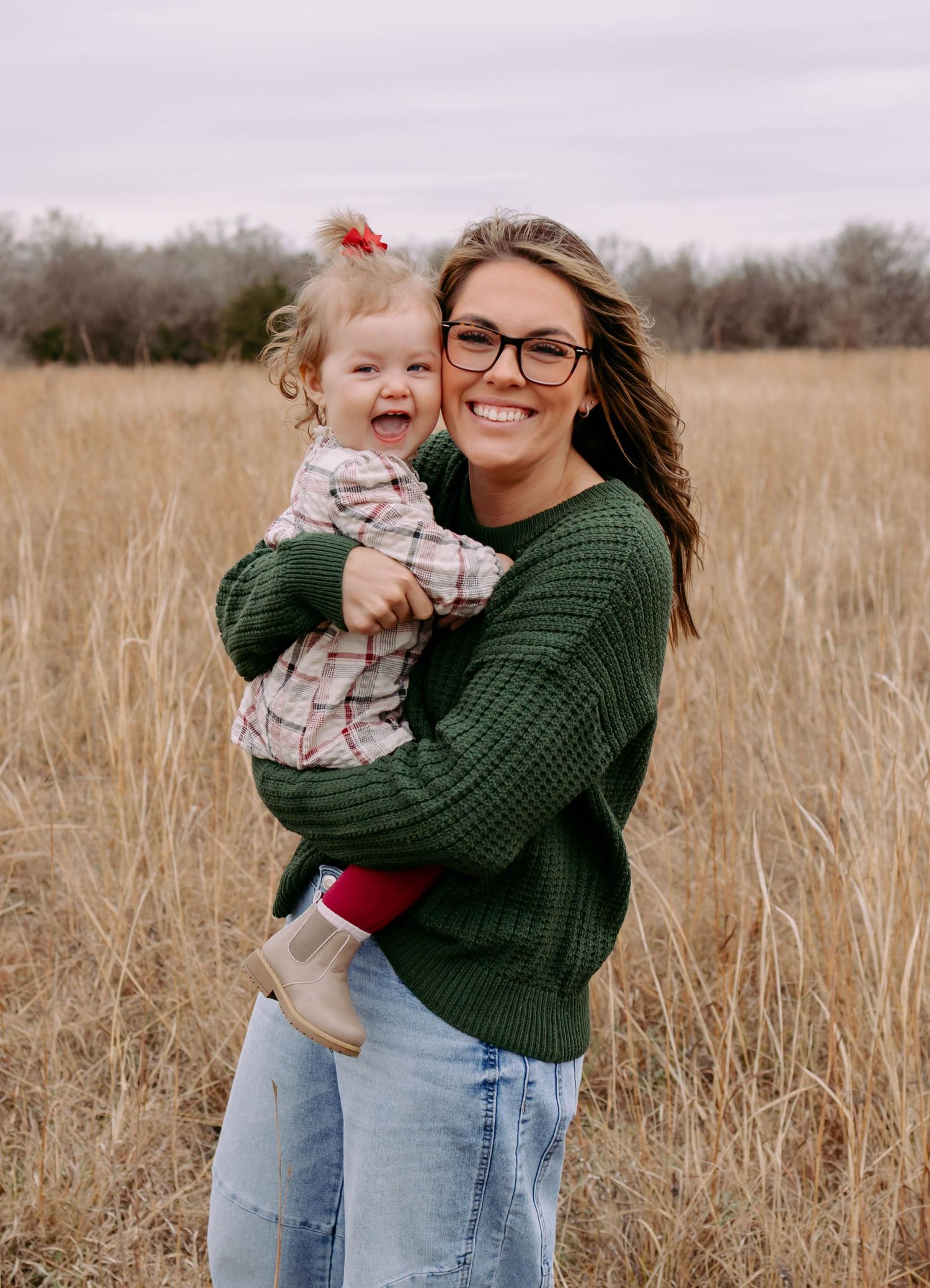 True West Photography - Mother and child sharing joyful embrace in tall grass field during autumn.