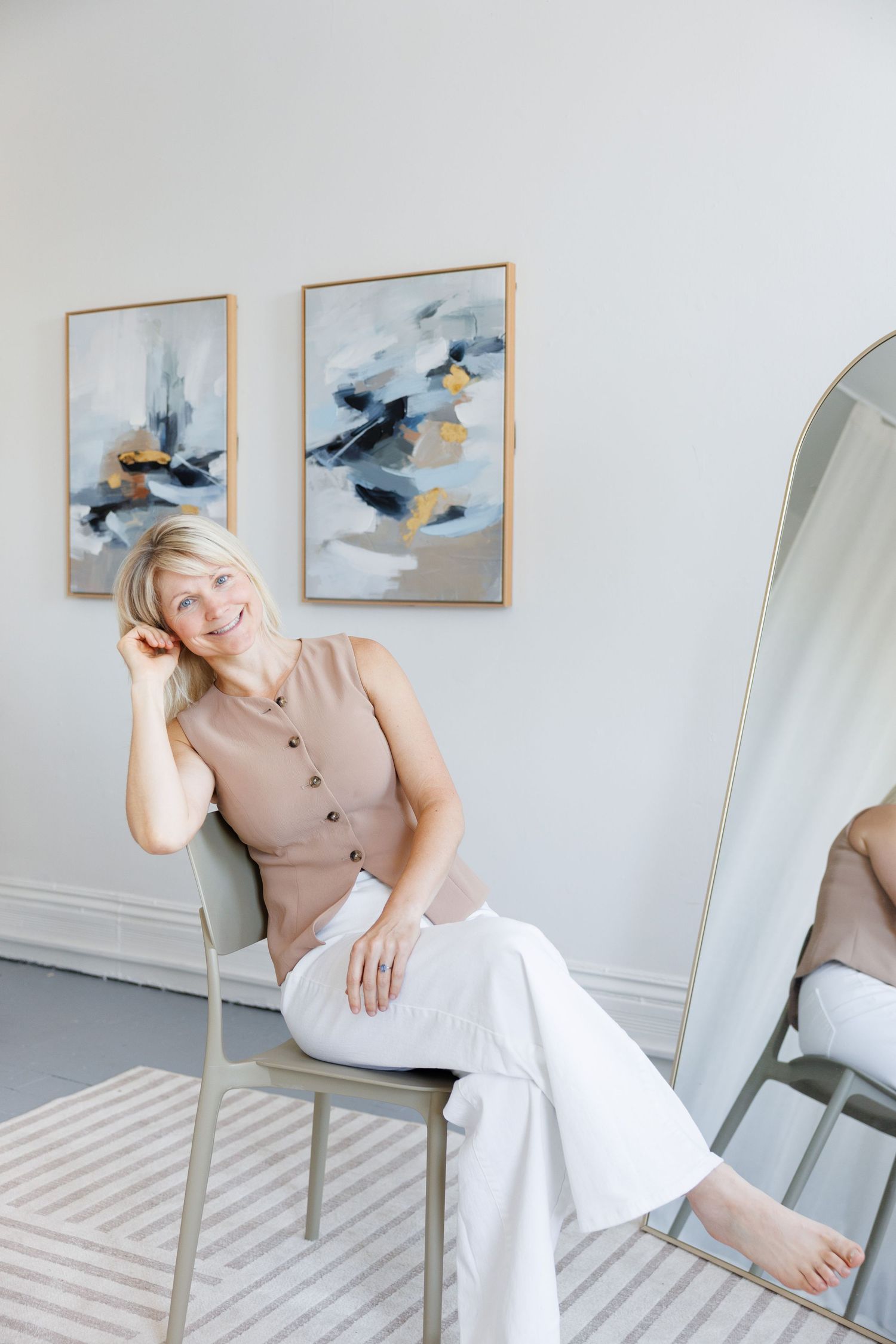 A series of artistic photos showing a person in a beige top and white pants posing on a chair against a light wall with bird art.