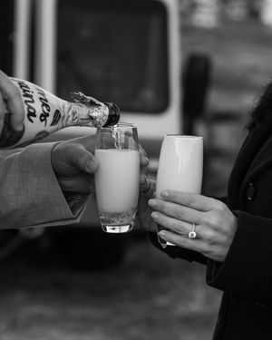 Black and white photo of hands holding coffee cups in a casual social gathering.