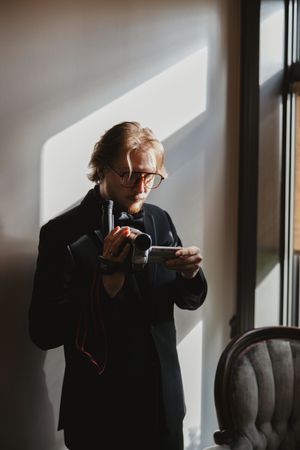 A series of moody window portraits showing a person in glasses sipping from a cup.