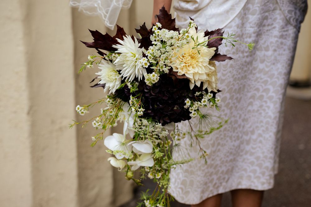 A collection of white and cream floral wedding bouquets arranged with delicate blooms and greenery.