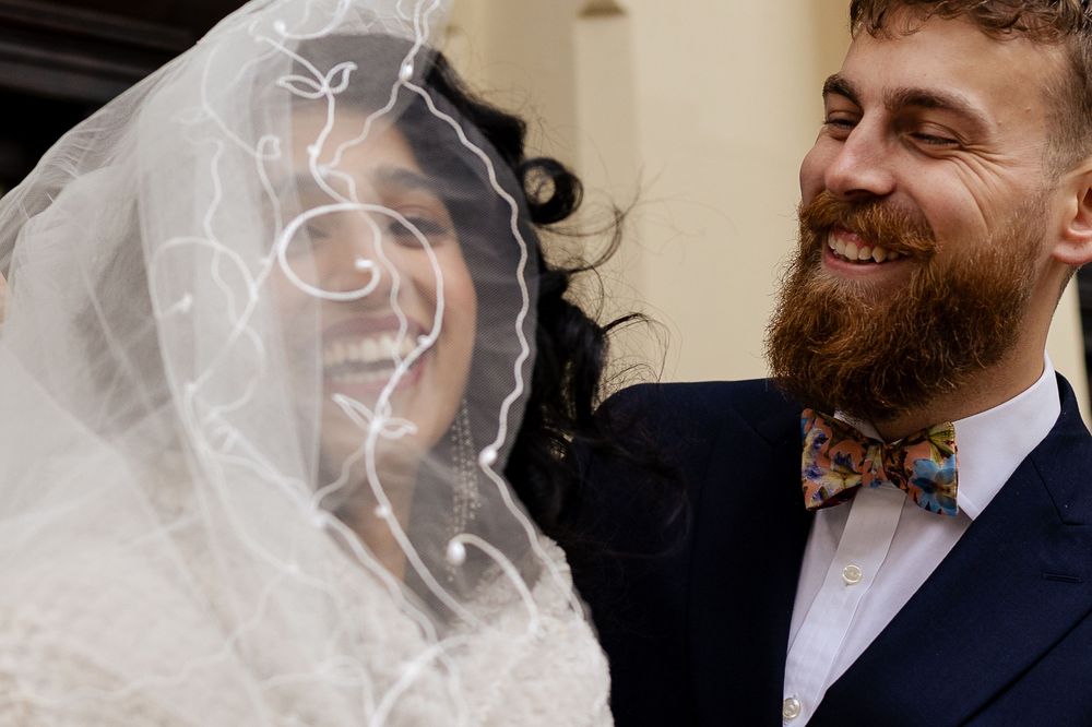 A bride and groom share a joyful moment together during their wedding celebration.