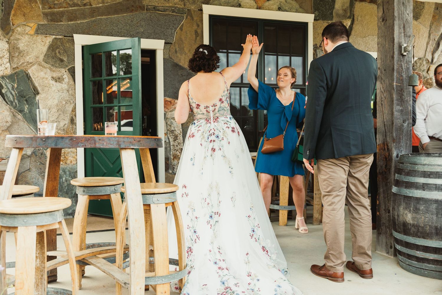Wedding celebration inside rustic barn venue with stone walls and wooden barrels.