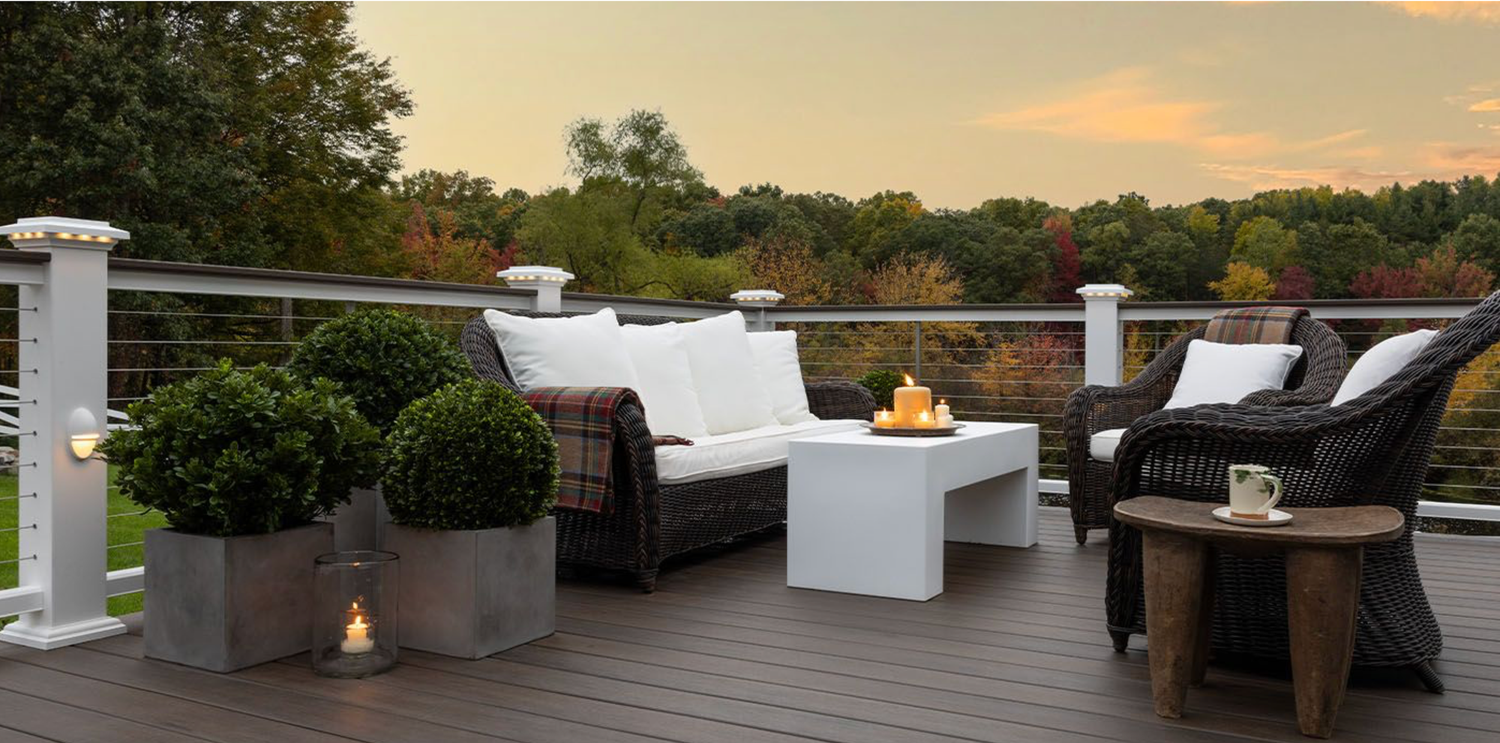 Modern outdoor patio with fire pit and lounge furniture at sunset overlooking scenic landscape views.