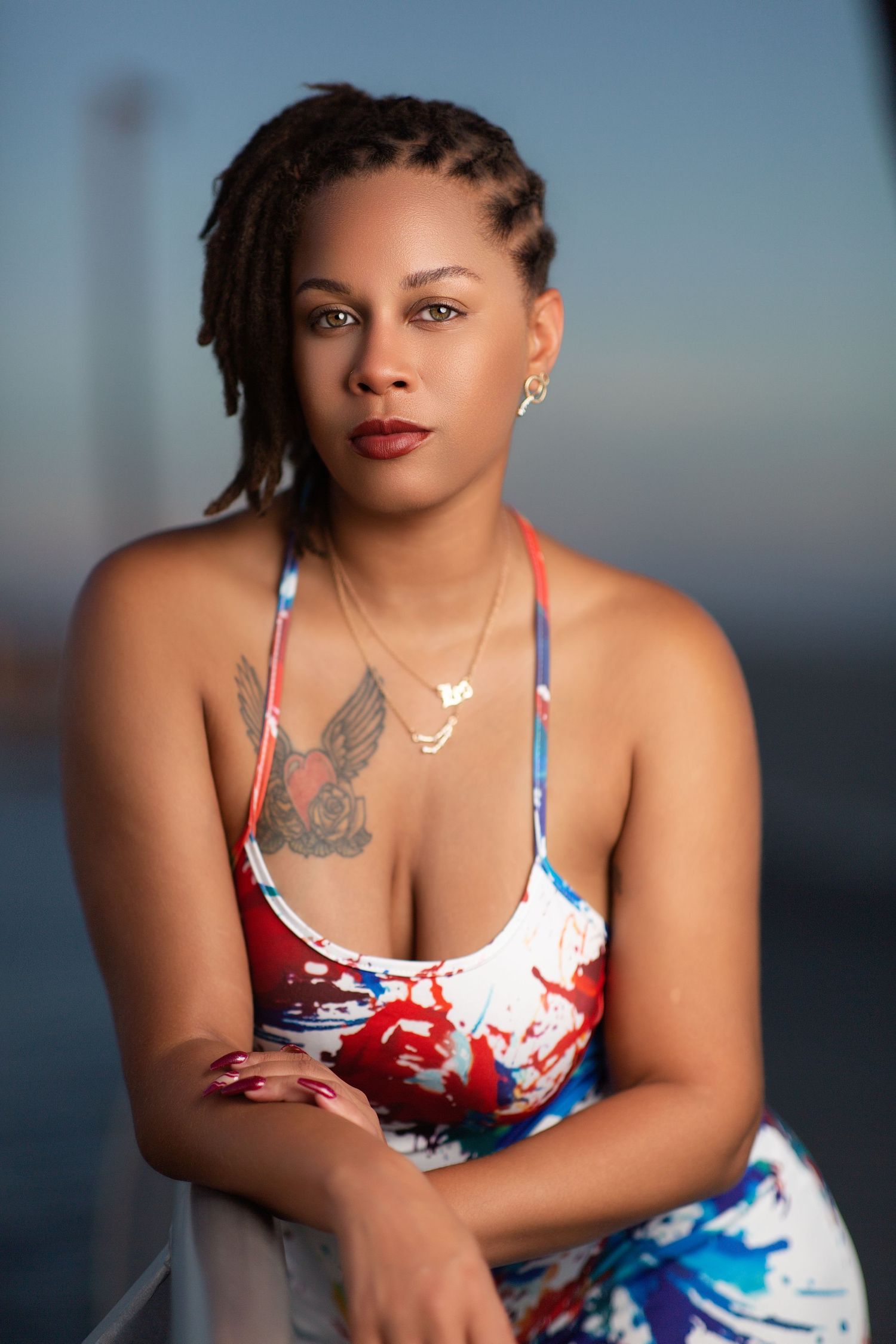 A portrait series showing someone in a red, white and blue patterned top against a blurred blue background.
