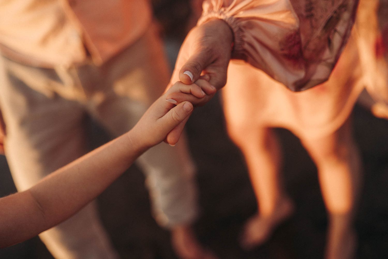 Hands clinking wine glasses together in celebration during a toast at a social gathering.