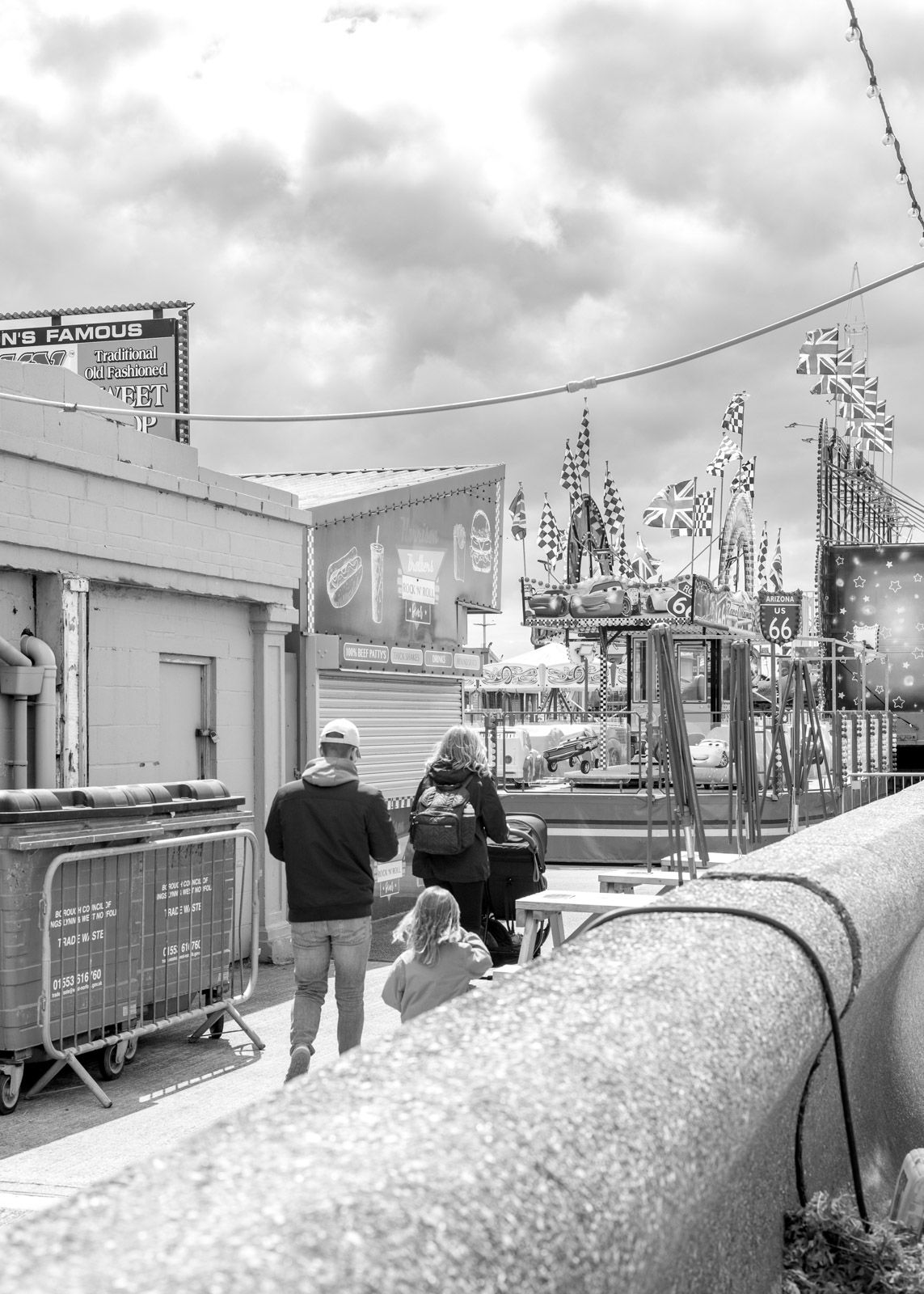 Panoramic black and white winter scene of train cars covered in snow at a railroad station platform.