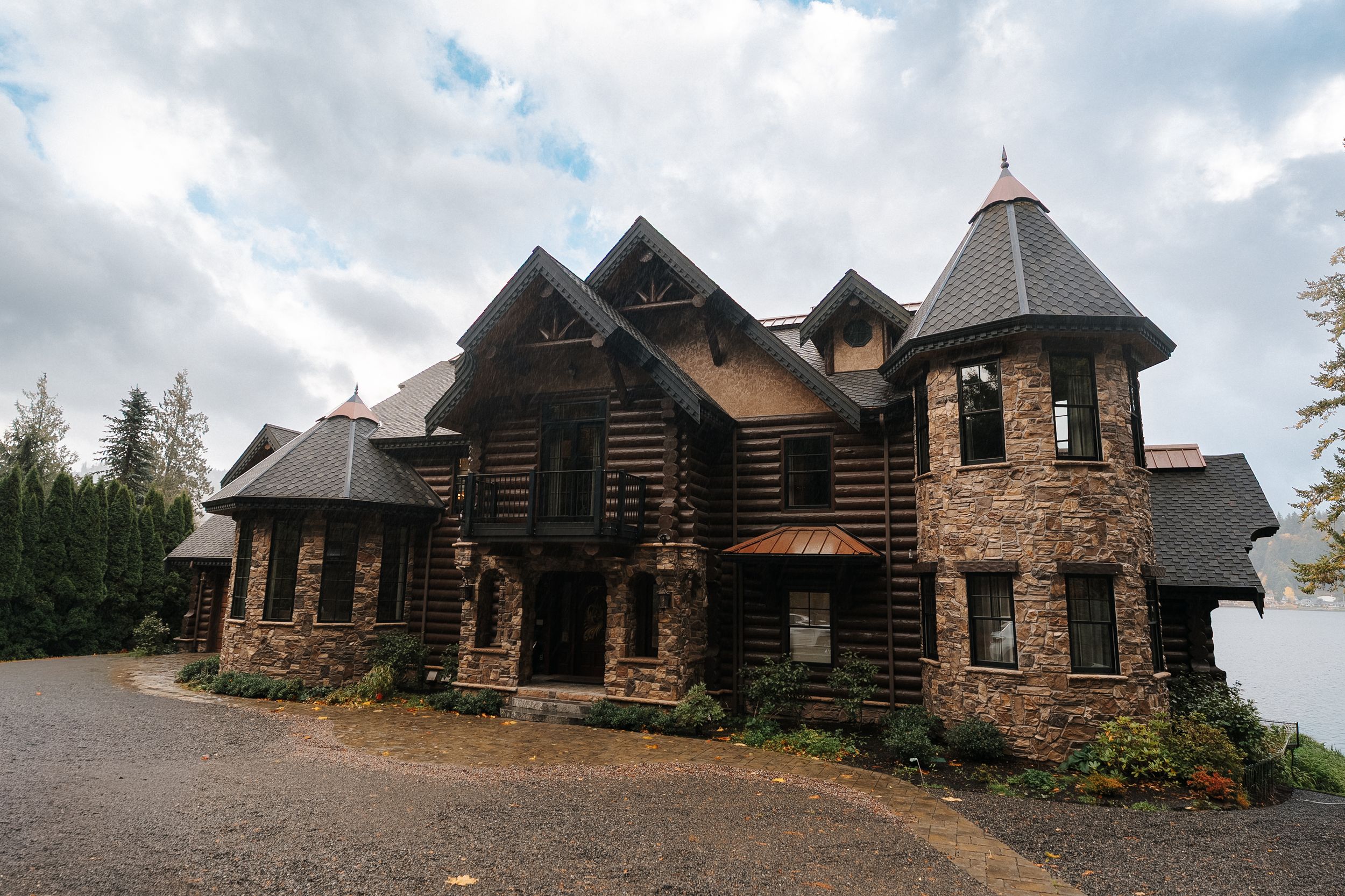 Panoramic view of an abandoned rustic log cabin church with multiple towers and wooden architecture in a rural setting.