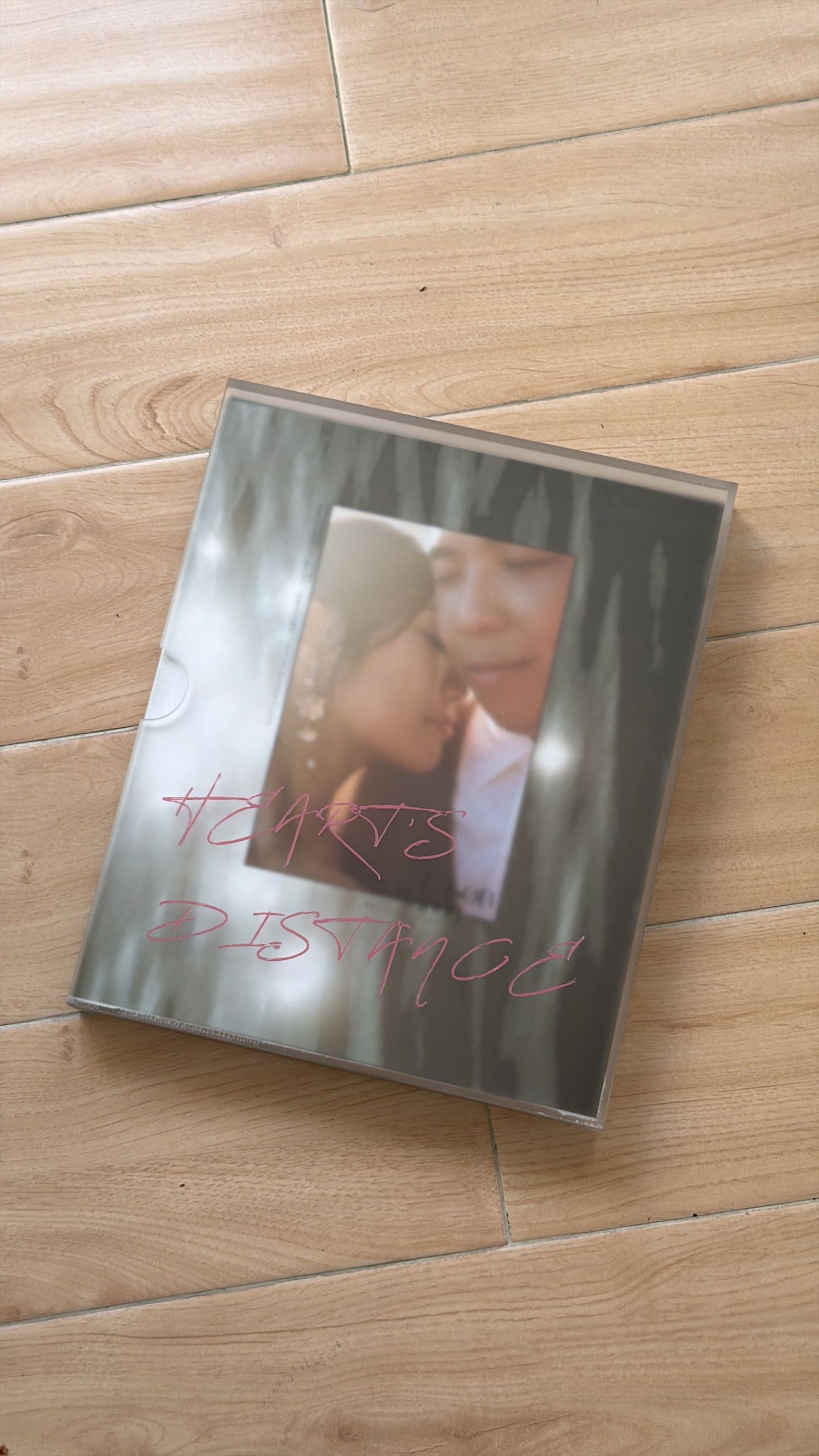 A romantic DVD or Blu-ray case showing a close-up image lies on light wooden flooring.