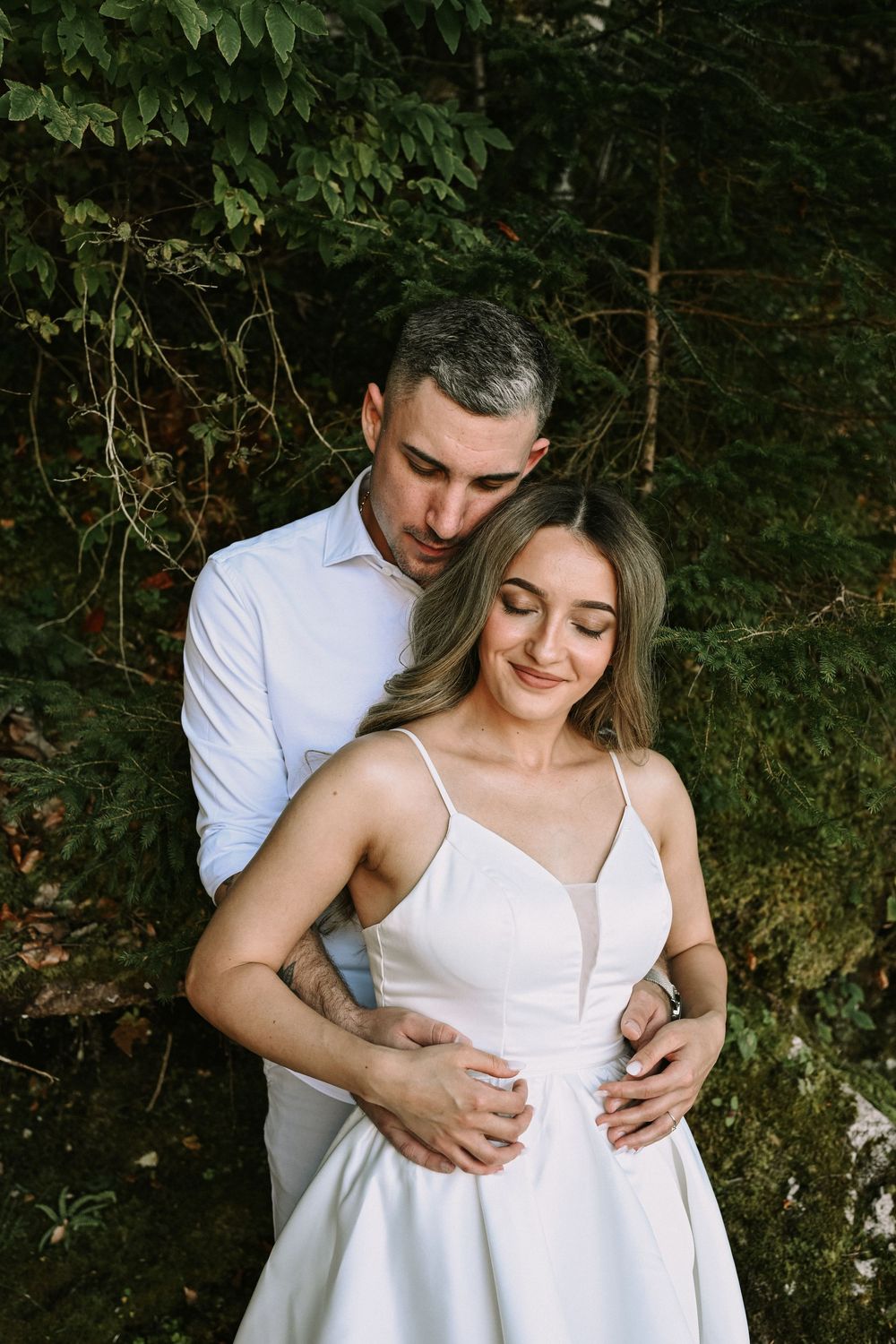 A tender embrace captured against lush green foliage in summer.