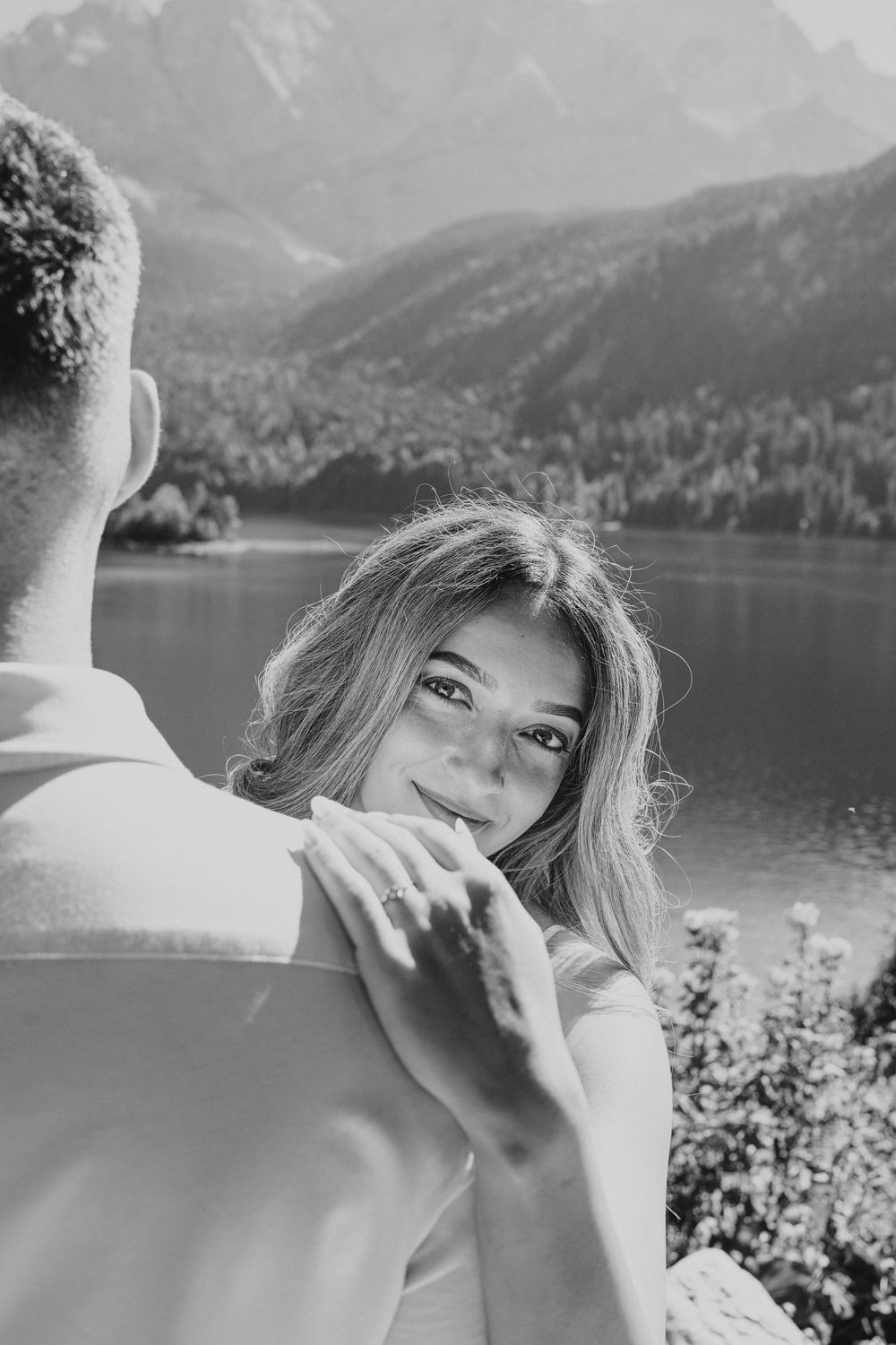 A romantic black and white portrait with a serene mountain lake in the background.
