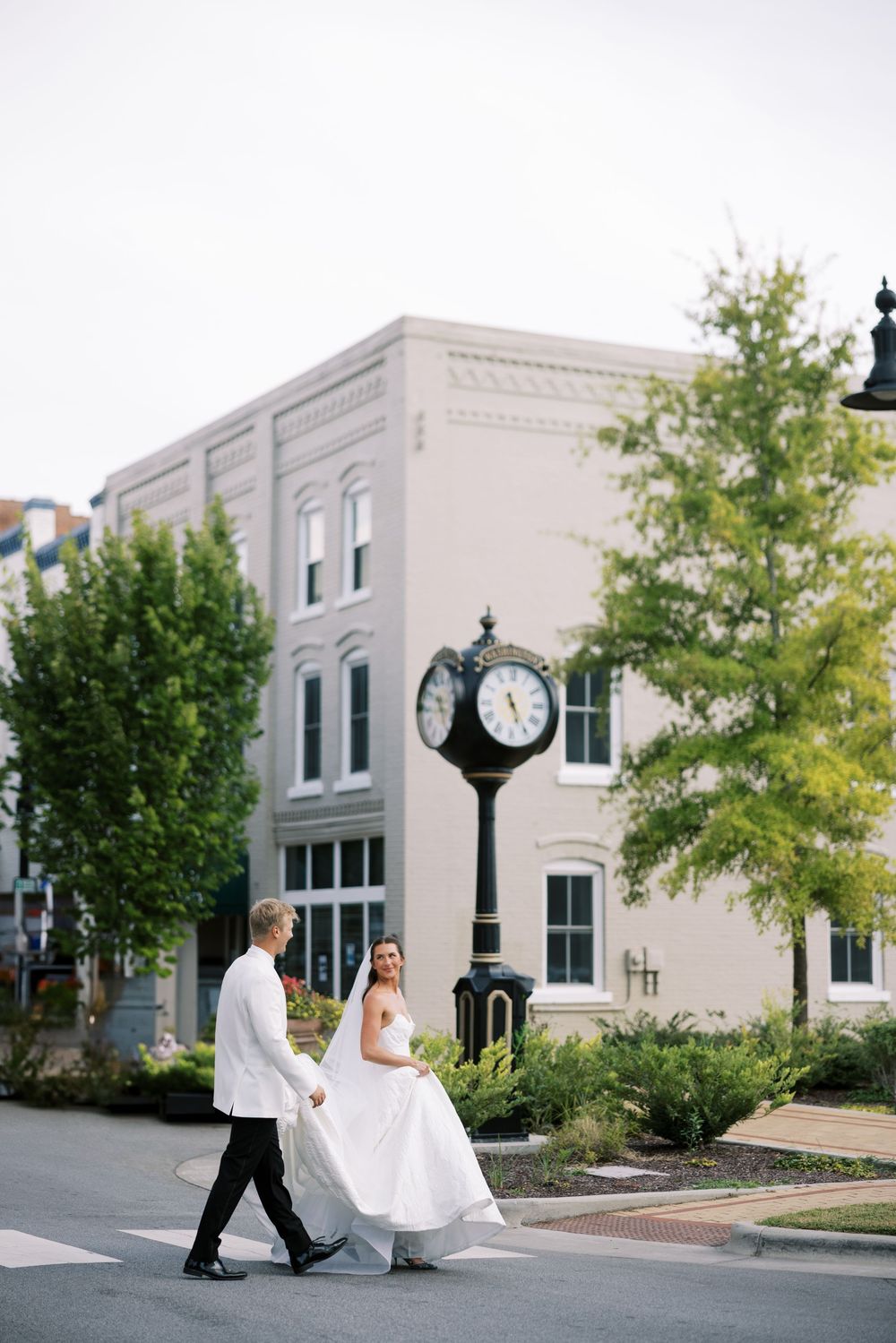 A series of romantic wedding photos taken against a modern urban backdrop with lamp posts and trees. NC WEDDING PHOTOGRAPHER