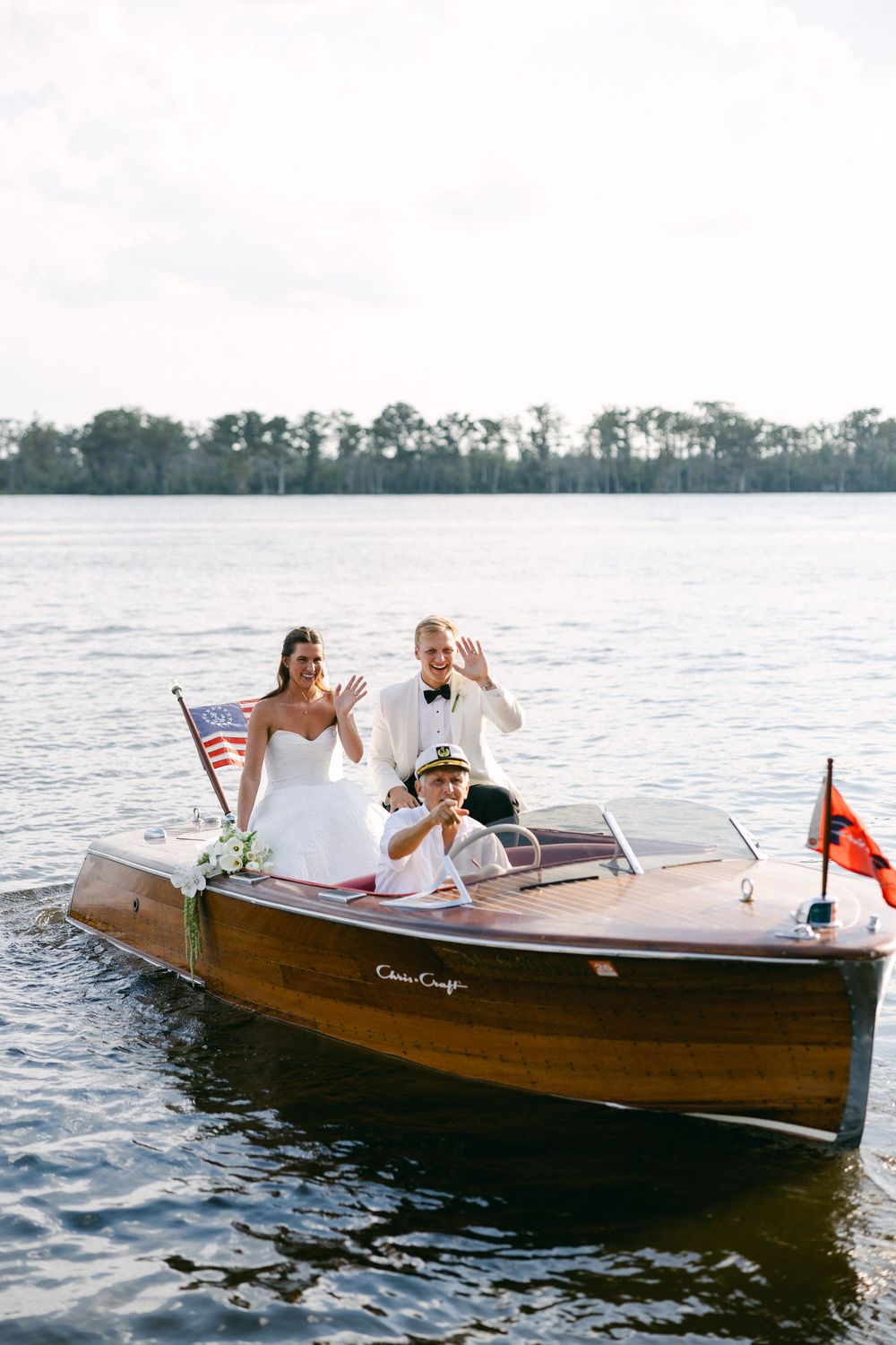Wedding couple enjoying a romantic boat ride in a vintage wooden Casablanca motorboat. NC WEDDING PHOTOGRAPHER
