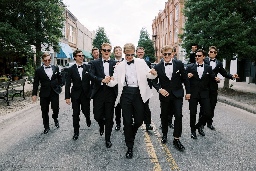 Group in formal black and white attire walking together down a street in a candid sequence of photos.NC WEDDING PHOTOGRAPHER