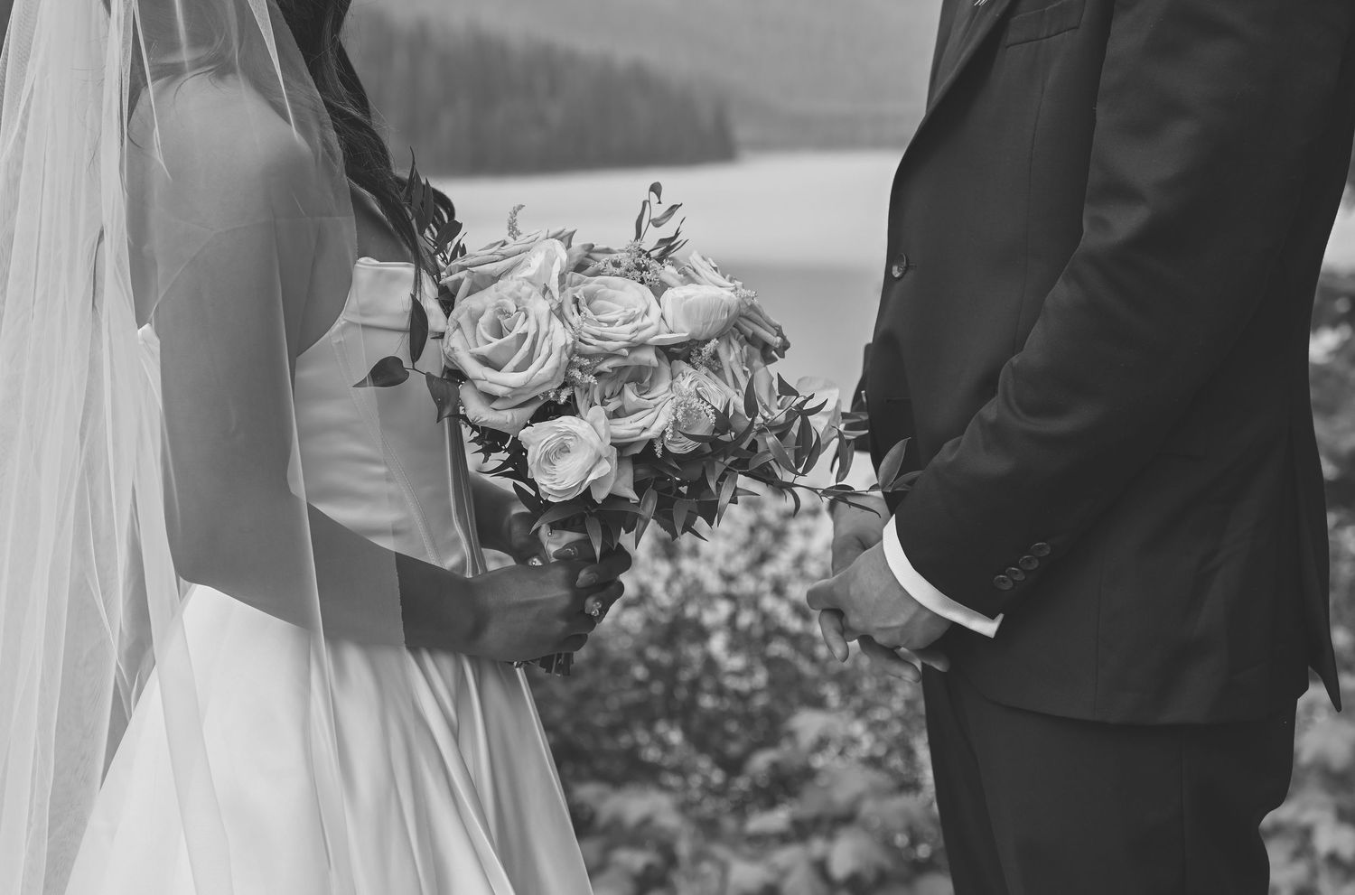 A bride and groom share an intimate moment during their wedding ceremony with guests looking on.