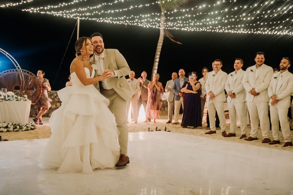 A couple shares their first dance under twinkling string lights  El Dorado Royale Wedding Photographer