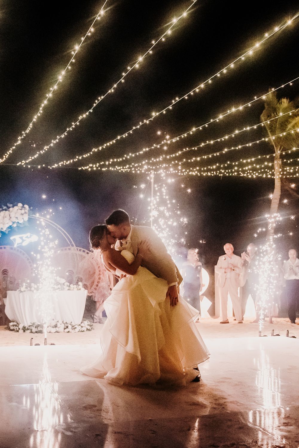 A romantic first dance sequence under twinkling string lights at an outdoor evening wedding reception. El Dorado Royale Wedding Photographer