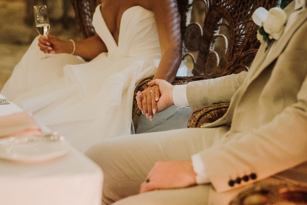 Close-up of hands signing documents at a desk with pens and papers arranged neatly. El Dorado Royale Wedding Photographer