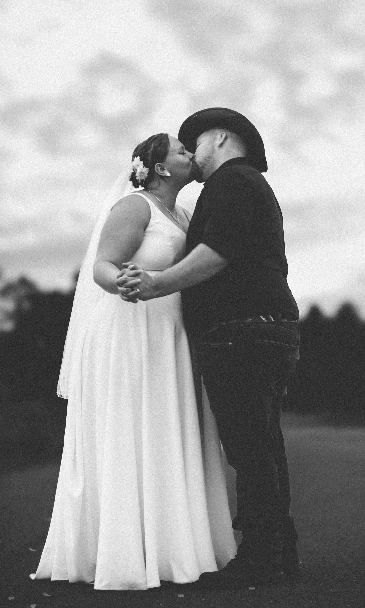 Black and white portrait of couple embracing in romantic outdoor setting.