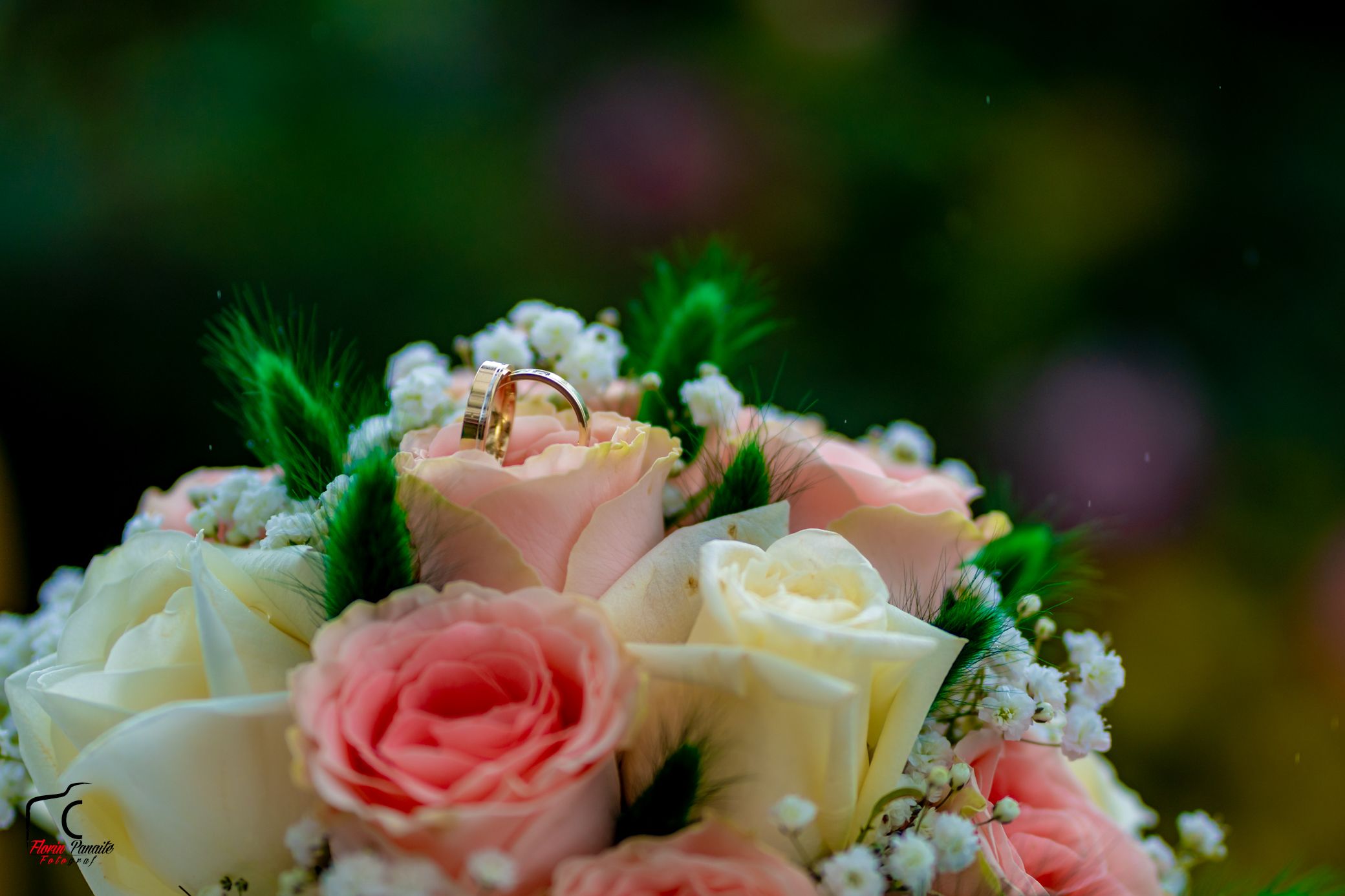 Wedding flower arrangement featuring blush pink and cream roses with greenery.