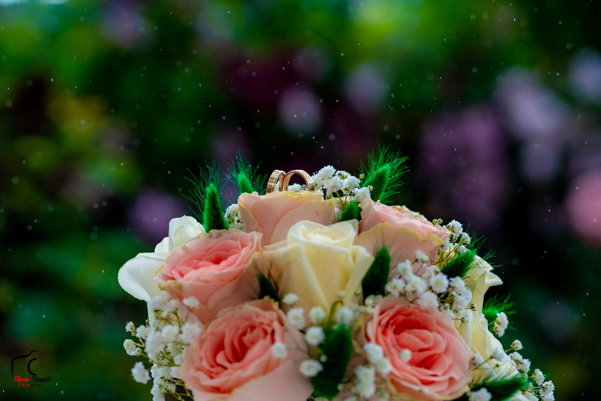 Elegant bridal bouquet with pink and ivory roses against blurred garden background.