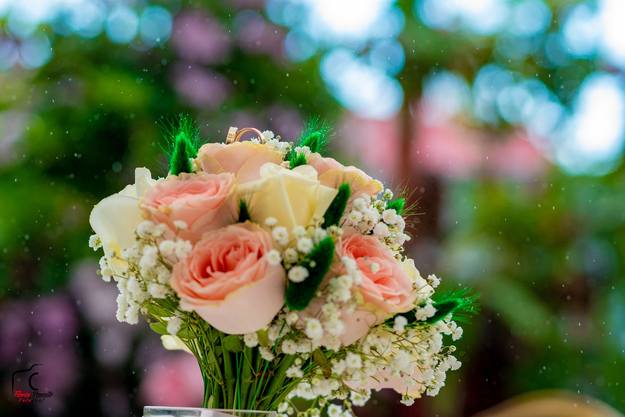 Delicate pink roses and baby's breath flowers arranged in a romantic bouquet against a soft bokeh background.