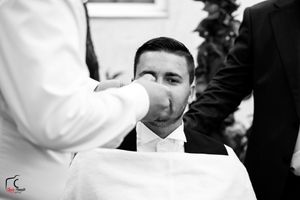 Black and white candid shot of people in formal attire at outdoor event.