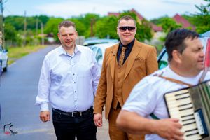 People walking outdoors with person carrying accordion in casual setting.