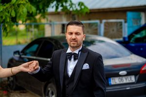 Formal event guests gathering outdoors in black suits.