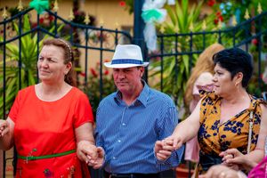 Group dancing together at an outdoor celebration with decorative green lighting.