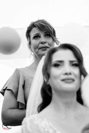 Black and white portrait of wedding party with elegant decor and soft lighting.