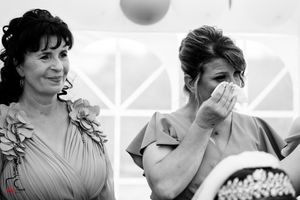 Black and white capture of emotional wedding guest reactions during ceremony.