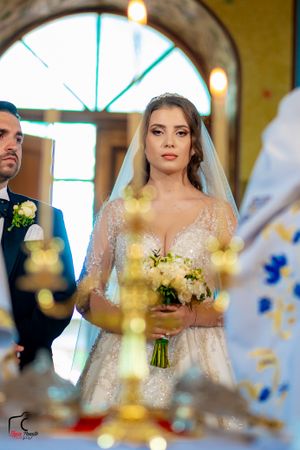 A wedding ceremony in a church with sunlight streaming through arched windows.