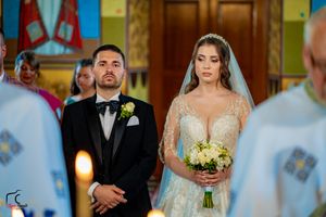 Wedding ceremony participants standing at the altar in a beautifully decorated church.
