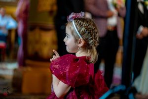 Young children in formal attire watching intently during a wedding ceremony.